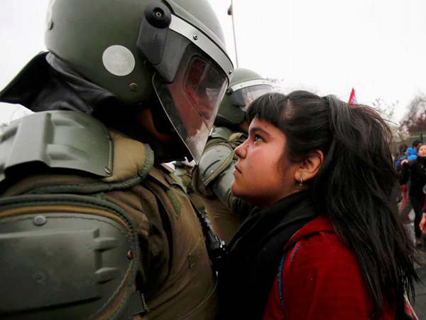 The young demonstrator locked eyes with a riot policeman during a pro democracy protest in Santiago, Chile 