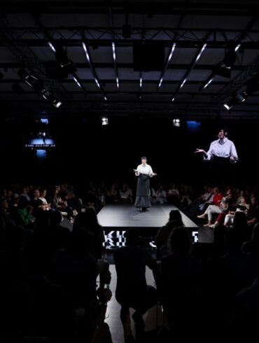 Govornica na dugačkoj catwalk pozornici okruženoj publikom s obje strane i četiri velika ekrana s njezinim likom, u tamnoj dvorani Dana komunikacija 2026.