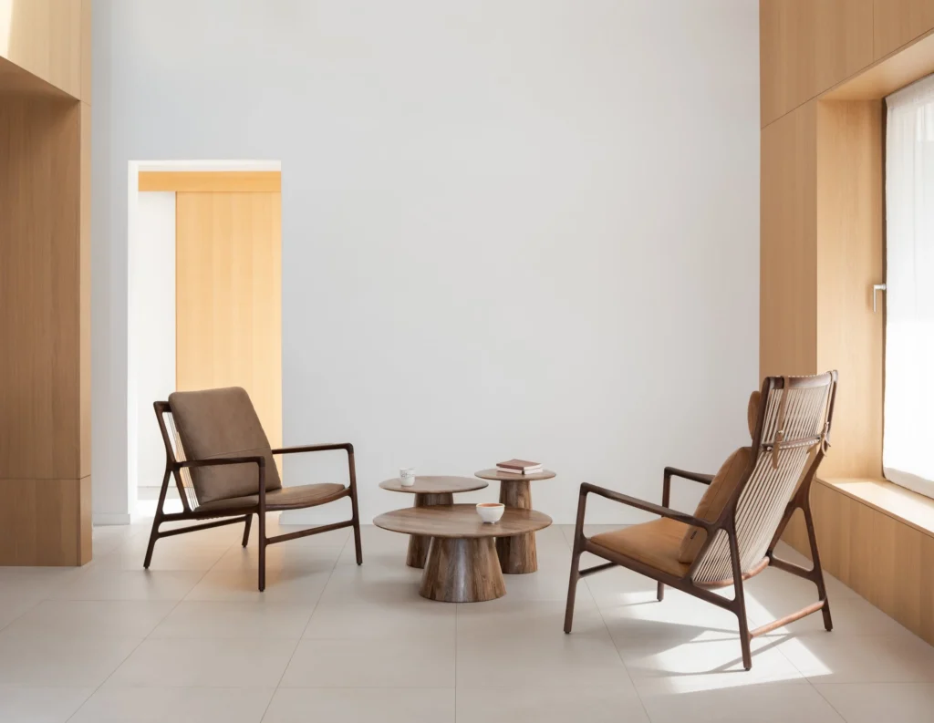 Gazzda Dedo easy chair i Dedo lounge chair od oraha s Dakar kožom u bojama stone i whisky, Mushroom stolići od uljanog oraha, minimalistički enterijer s visokim stropom i drvenim oblogama