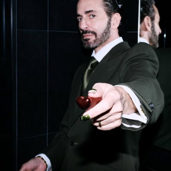 Marc Jacobs u tamnozelenom odijelu pruža maleno srce prema kameri, s odrazom u ogledalu u pozadini — fotografija s njegovog Instagram profila @themarcjacobs