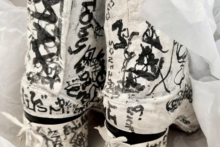 Bijele Tabi čizme s razdvojenim prstima prekrivene crnim grafitima, iz osobne arhive Martina Margiela