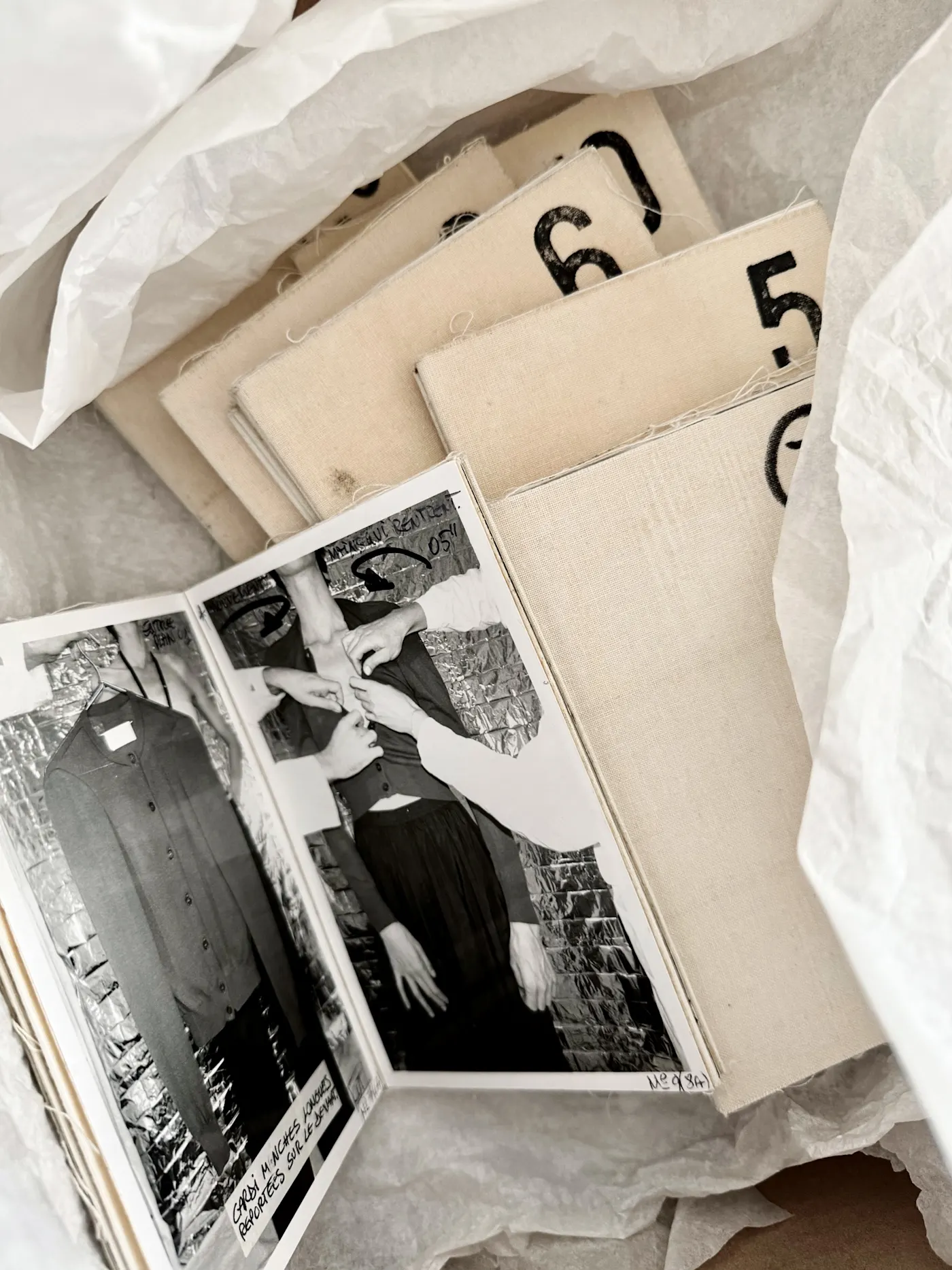 Složeni lookbookovi iz arhive Maison Martin Margiela, s crno-bijelim fotografijama i brojevima otisnutim na platnu