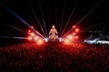 Monumentalna skulptura EXIT to Montenegro festivala osvijetljena zlatnom svjetlošću iznad publike na Velikoj plaži u Ulcinju