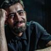 Irfan Ribić, osnivač i umjetnički direktor RAW SOUL THEATRE, naslonjen na sto u zatamnjenom prostoru teatra