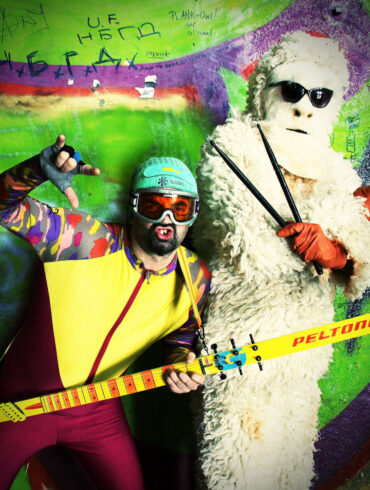 Skier & Yeti, beogradski duo, pozira u kostimima skijaša i Yetija sa instrumentima Skitarom i drumsticima ispred grafitima ispisanog zida