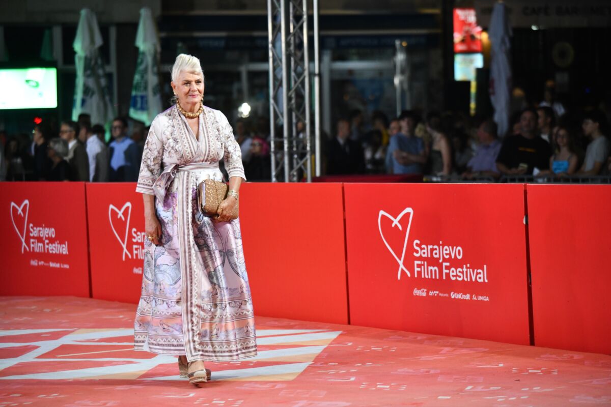 Mama Elme Tataragić, dugogodišnja gošća festivalskog crvenog tepiha, u haljini bogatog ornamentalnog printa i sa zlatnim detaljima.