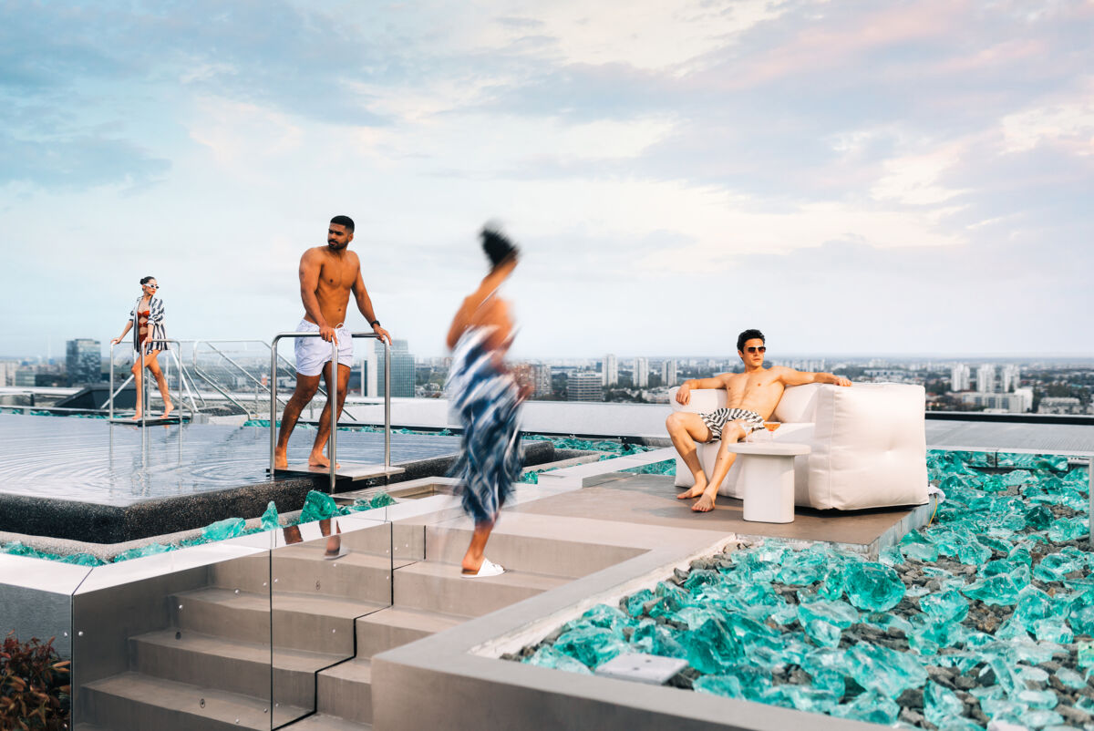 Cherry Pop Rooftop bazen sa gostima koji se zabavljaju u vodi tijekom dana, sunčan ambijent sa pogledom na grad