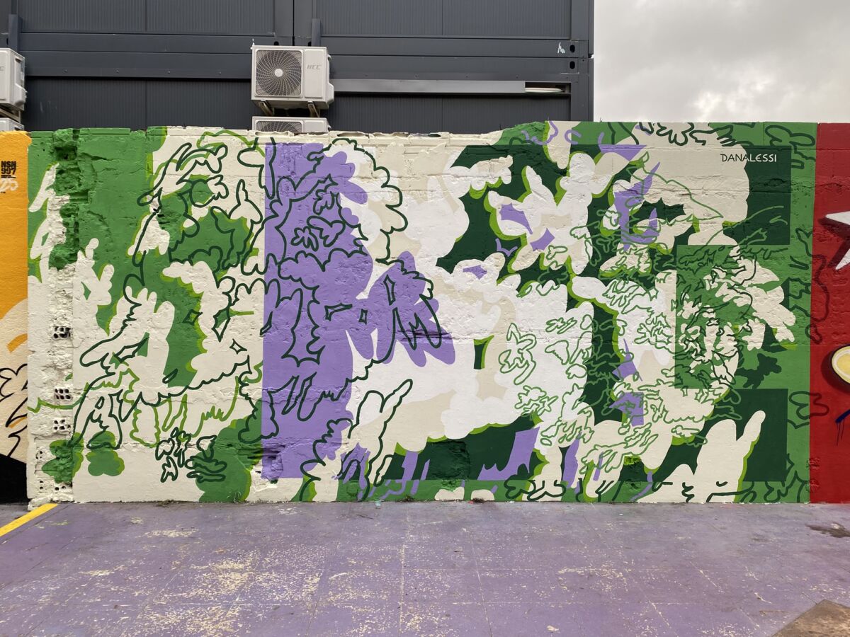 Jardín Interior, mural Dane Alessi u Barceloni 2025., s apstraktnim floralnim oblicima u zelenim, ljubičastim i svijetlim tonovima.